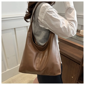 Detailed texture of brown PU leather hobo bag with minimalist vertical stitching detail