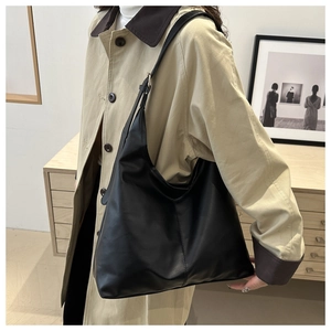 Detail view of large black PU leather tote bag with adjustable strap and silver metal buckle