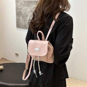 Pink minimalist nylon mini backpack for women shown from a back perspective view