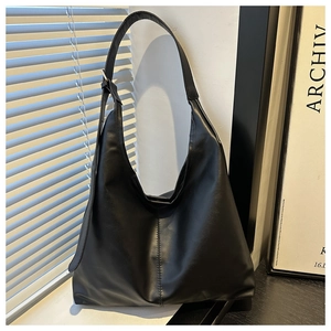 Close-up of black PU hobo bag with adjustable silver buckle and vertical stitching detail