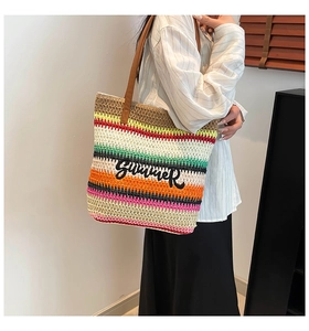 Detail of multi-color striped woven tote with Summer embroidery and leather handles