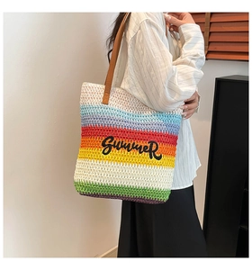 Detail of rainbow straw tote bag featuring Summer embroidery and brown leather straps