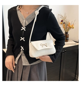 Vue détaillée du sac en cuir PU blanc avec nœud doré et bandoulière à nœuds élégante