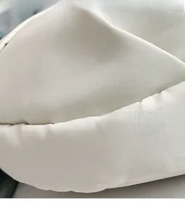 Detailed macro shot of lightweight off-white canvas fabric with fine stitching quality