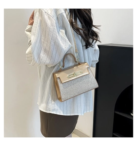 Detail of champagne gold glitter handbag with metallic clasp and adjustable strap