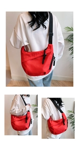 Detail of red nylon crossbody bag featuring large capacity and black adjustable strap