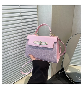 Macro detail of the pink glitter texture and golden buckle on this luxury handbag