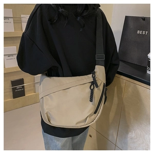 Rear view of a beige crescent nylon crossbody bag with adjustable wide black strap