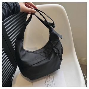 Detailed close-up of a black crescent nylon bag with woven rope zipper and buckle strap