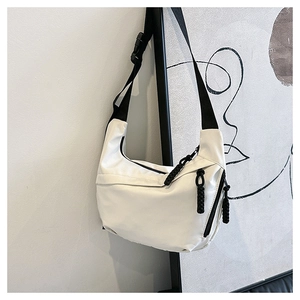 Detail of white crescent crossbody bag with adjustable black strap and rope zipper puller