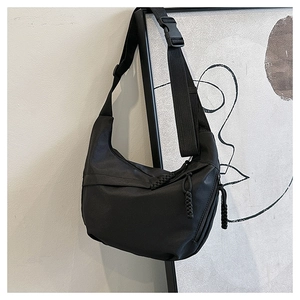 Detail of black crescent crossbody bag with thick shoulder strap and nylon buckle closure