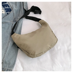 Detail of khaki crescent crossbody bag with textured fabric and adjustable strap