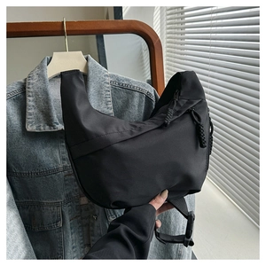 Detail of black crescent crossbody bag featuring durable nylon and adjustable wide strap