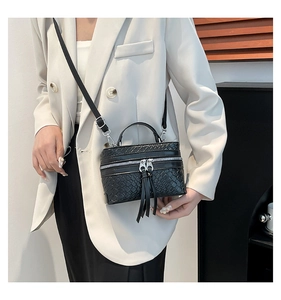 Detail of black woven texture box bag with double zippers and slim shoulder strap