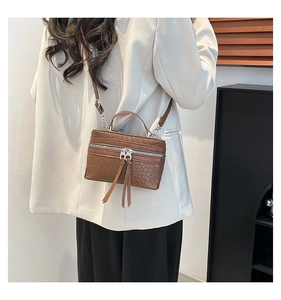 Detail of brown woven texture crossbody bucket bag with long tassel double zippers