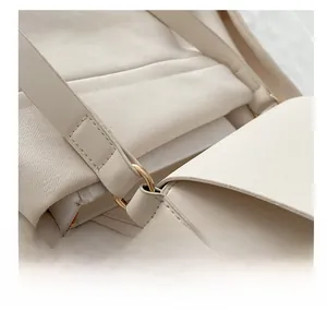 Détail de la texture cuir PU blanc et boucle en métal doré avec coutures fines
