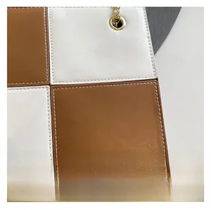 Detailed view of two-tone checkered bag featuring precise stitching and gold metal eyelet