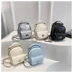 Detailed macro view of quilted mini backpacks in multiple colors with chain straps
