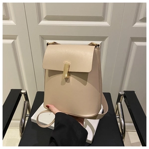 Dettaglio dello zaino in pelle beige strutturata con chiusura a cilindro in metallo dorato