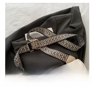 Detail of beige pillow bag with a wide geometric ethnic pattern woven shoulder strap