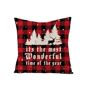 Détail d'une housse de coussin de Noël à carreaux rouges et noirs avec renne et texte