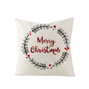 Détail d'une housse de coussin en lin avec texte Merry Christmas rouge et couronne