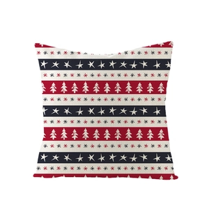 Détail d'une housse de coussin en lin avec sapins de Noël rouges et motifs d'étoiles