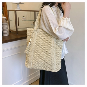 Detail of woven straw tote bag with beaded tassels in a cozy cafe setting