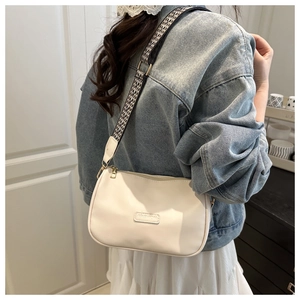 Detail of white PU pillow bag featuring a FASHION patch and checkered crossbody strap