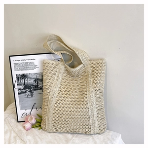 Detail showing the intricate hollow weave texture and sturdy handles of this straw tote bag