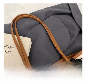 Detail of durable brown leather handle and woven texture on a large retro tote bag