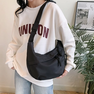 Minimalist black nylon crescent crossbody bag with adjustable wide strap for daily commute