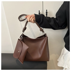 Detailed shot of dark brown tote bag set with knotted handles and a matching mini pouch