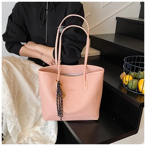 Detail of pink lychee leather tote bag with FASHION text and striped silk scarf accessory