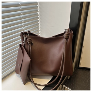 Detail of chocolate brown tote bag with knotted handles and small matching pouch