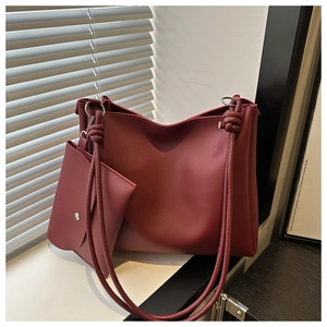 Detail of burgundy leather tote bag with round cord handles and matching inner pouch