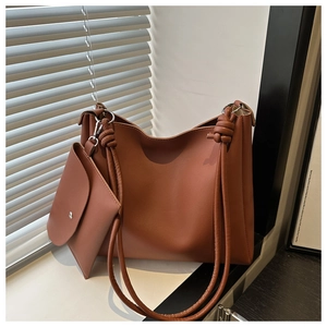 Detailed shot of brown vintage leather tote bag with a small pouch and knot handle detail