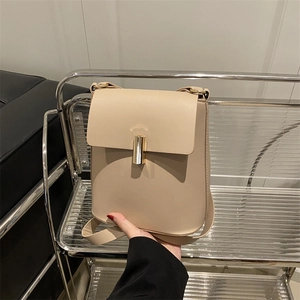 Borsa a tracolla beige minimalista con elegante dettaglio di chiusura cilindrica dorata