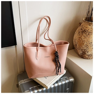 Detail of pink lychee leather tote bag with FASHION logo and striped silk scarf