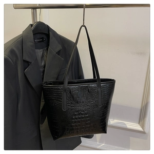 Close-up of black crocodile pattern faux leather tote bag showing textured finish