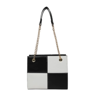Minimalist black and white color-block crossbody bag with gold chain and leather handle