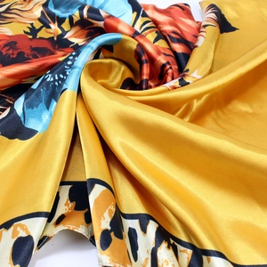 Détail d'un foulard en satin de soie avec imprimé léopard et fleurs, texture brillante