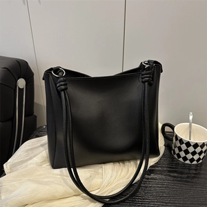 Minimalist black leather tote bag with silver metal rings and knots for women