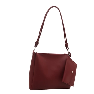 Chic burgundy leather bucket bag with decorative knot strap and matching coin purse