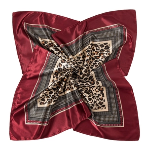 Détail macro du foulard carré bordeaux avec imprimé léopard et motifs de chaînes géométriques