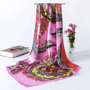 Detailed shot of pink paisley silk scarf draped with vintage books and glasses