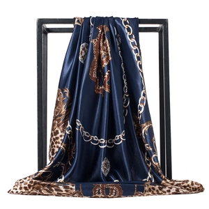 Detail of royal blue leopard and chain print satin scarf with elegant draped folds