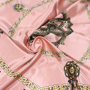 Close-up of silk-like satin square scarf featuring golden chain and leopard print patterns