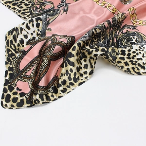 Detail of pink leopard and gold chain print scarf with elegant satin luster and silk feel