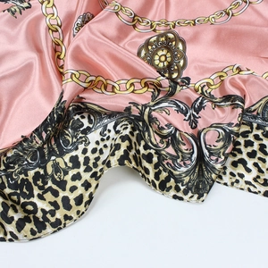 Detailed view of silk satin scarf featuring luxury gold chains and leopard print textures
